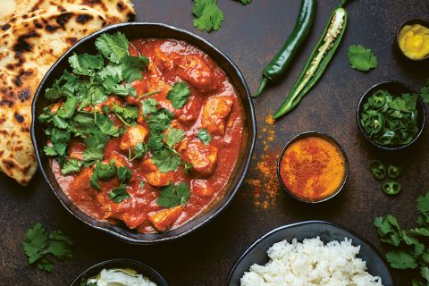 El tradicional chicken tikka masala, el plato de curry más difundido de la cultura india se sirve con arroz basmati, pan naan y yogur.